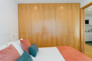 um quarto com uma cama com painéis de madeira em Oporto Yellow Apartments no Porto