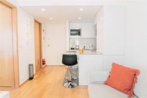 a living room with a chair and a kitchen at Oporto Yellow Apartments in Porto