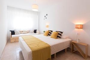 een slaapkamer met een groot bed en een bank bij Beach Paradise Flat in Denia Centre w/ Large Pool in Denia
