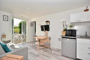 uma cozinha e sala de estar com um sofá e uma mesa em Gîte le Mizériat - Appartement avec piscine privée em Saint-Didier-sur-Chalaronne