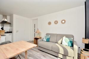 uma sala de estar com um sofá e uma mesa em Gîte le Mizériat - Appartement avec piscine privée em Saint-Didier-sur-Chalaronne