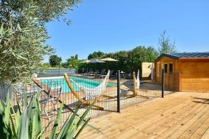 una terraza con sillas y una piscina en Gîte le Mizériat - Appartement avec piscine privée, en Saint-Didier-sur-Chalaronne