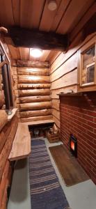 a room with a fireplace and a wooden wall at Raistiko sauna cabin / Raistiko saunamaja 