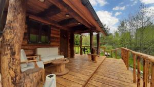 a porch of a log cabin with a couch and a table at Raistiko sauna cabin / Raistiko saunamaja 