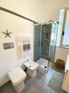 a bathroom with a shower and a toilet and a sink at Alloggio 2 / Casa Marley Porto Pollo in Barrabisa
