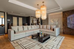 a living room with a large couch and a table at Amman Rotana in Amman