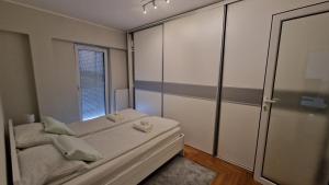una piccola camera con letto e finestra di Lux Apartman Ava a Kikinda
