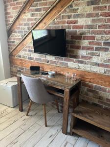 a wooden desk with a television on a brick wall at Penzión Pri Mlyne in Nitra