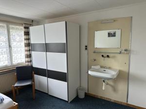La salle de bains est pourvue d'un lavabo et d'un miroir. dans l'établissement HOTEL CHRISTINA, à Wilderswil