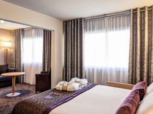 a hotel room with a bed and a window at Mercure Lyon Charbonnières in Charbonnières-les-Bains