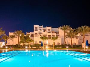 uma grande piscina em frente a um grande edifício branco em Mercure Hurghada Hotel em Hurghada