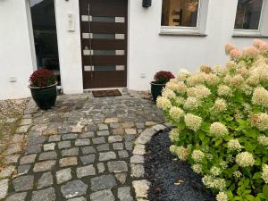 uma casa com dois vasos de plantas na frente de uma porta em 4 bedrooms and 2 bathrooms plus kitchen and terrace- 10 min to fairground em Dusseldorf