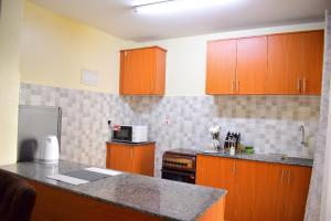 a kitchen with wooden cabinets and a counter top at Elegant Furnished 2 bedroom Apartment in Nairobi Ngara in Nairobi +11 photos