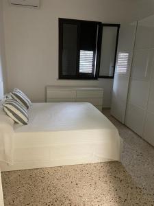 - un lit blanc dans une chambre avec fenêtre dans l'établissement Villa da "Giacomino l'Americano", à Cinisi