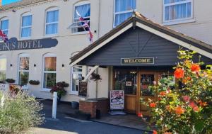 a hotel with a welcome sign in front of a building at Bacchus Hotel in Sutton on Sea