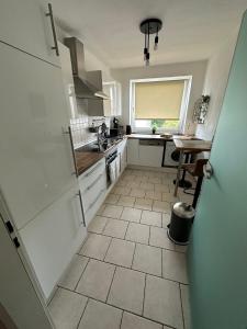eine Küche mit weißen Geräten und Fliesenboden in der Unterkunft Minimalharmony Apartment in Hannover