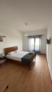 een slaapkamer met een bed en een houten vloer bij 7 Requinte Guest House in Lissabon