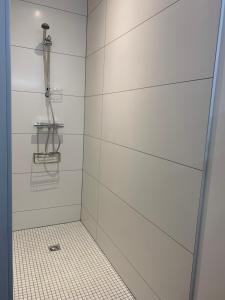 bagno con doccia e piastrelle bianche di Chez Claudine APPART COSY a Château-Gontier