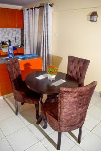 a dining room table with two chairs and a table with flowers on it at Elegant Furnished 2 bedroom Apartment in Nairobi Ngara in Nairobi