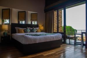 a bedroom with a large bed and a balcony at Inidi Leisure Luxury Villas in Wadduwa