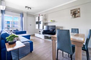 een woonkamer met een blauwe bank en een tafel bij Beachfront apartment in Armação in Armação de Pêra