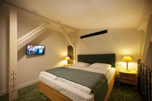 a bedroom with a bed and a tv on the wall at Grandhotel Ambassador Národní Dům in Karlovy Vary