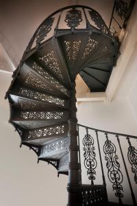 un escalier en colimaçon avec une balustrade en fer noir dans l'établissement Grandhotel Ambassador Národní Dům, à Karlovy Vary