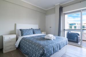 Un dormitorio con una cama y una ventana grande. en Beachfront apartment in Armação, en Armação de Pêra