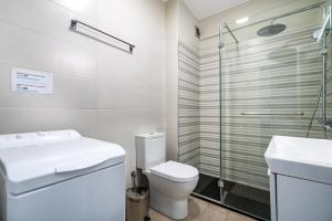 a bathroom with a toilet and a sink and a shower at Beachfront apartment in Armação in Armação de Pêra