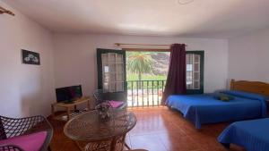 a bedroom with a bed and a table and a balcony at Apartamento Nelly S4 in Valle Gran Rey