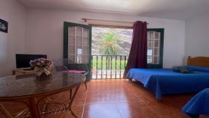 a room with a bed and a table and a balcony at Apartamento Nelly S4 in Valle Gran Rey