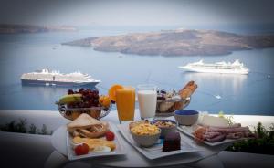 - une table avec un plateau de produits pour le petit-déjeuner et des boissons dans l'établissement Fanari Vista Suites, à Fira