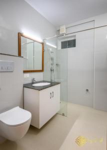 e bagno con servizi igienici, lavandino e doccia. di Daffodils Luxury Airport Suites a Cochin