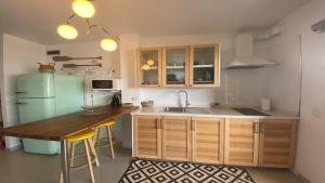 a kitchen with a green refrigerator and a wooden table at Apartamento La Ola in Valle Gran Rey
