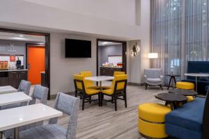 a waiting room with tables and yellow chairs at Hampton Inn & Suites Agoura Hills in Agoura Hills