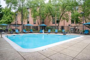 a swimming pool with blue chairs and a building at Hampton Inn Baltimore/White Marsh in White Marsh