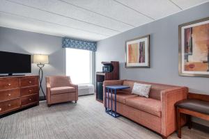 sala de estar con sofá y TV en Hampton Inn Baltimore/White Marsh en White Marsh