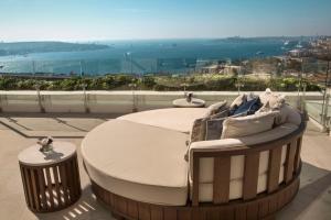 a bed on top of a building with a view at Conrad Istanbul Bosphorus in Istanbul