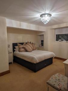 a bedroom with a large bed with a chandelier at The Rising Sun Inn in West Bagborough