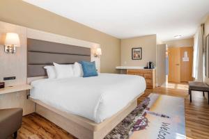 a hotel room with a large bed and a chair at Casco Bay Hotel, Ascend Hotel Collection in South Portland