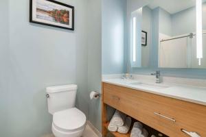 a bathroom with a toilet and a sink and a mirror at Casco Bay Hotel, Ascend Hotel Collection in South Portland
