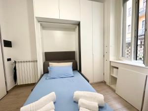 um pequeno quarto com uma cama azul e 2 cadeiras em Small house near the Station em Milão