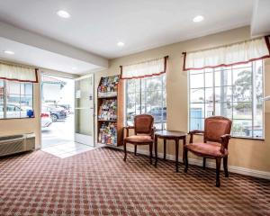 uma sala de espera com uma mesa, cadeiras e janelas em Rodeway Inn San Clemente Beach em San Clemente