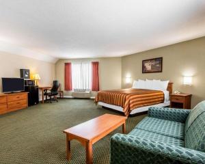 um quarto de hotel com uma cama e um sofá em Rodeway Inn San Clemente Beach em San Clemente