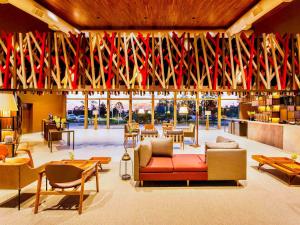 um átrio com sofás e mesas e bandeiras vermelhas em Novotel Itu Terras de São José Golf & Resort em Itu