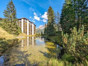 a river in front of a hotel with a mountain at Rothornblick 57 by Arosa Holiday in Arosa