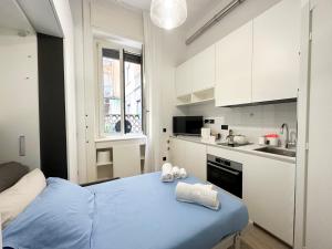 uma pequena cozinha com uma cama azul num quarto em Small house near the Station em Milão
