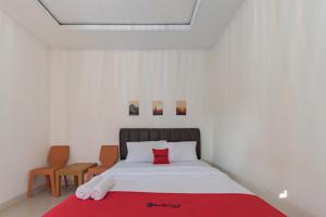 a bedroom with a bed with a red blanket at RedDoorz near Ciletuh Sukabumi in Cilowa +17 photos