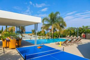 un tavolo da ping pong blu su un patio accanto alla piscina di Limni Beach Villa a Mavroli