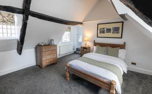 a bedroom with a bed and a dresser and window at The French Partridge, in Northampton